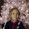 Photograph of a young boy in front of a Christmas Tree
